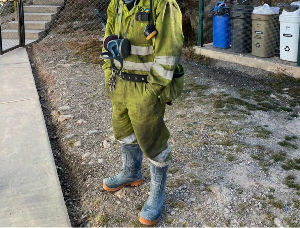 A Glore crew member at the Yaruchagua camp, beside the color-coded waste-segregation point